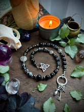 Load image into Gallery viewer, At the Crossroads - Witch’s Ladder, Altar Beads - Onyx, Snowflake/Smoky Obsidian, Iolite, Hematite - Triquetra, Keys Goddess